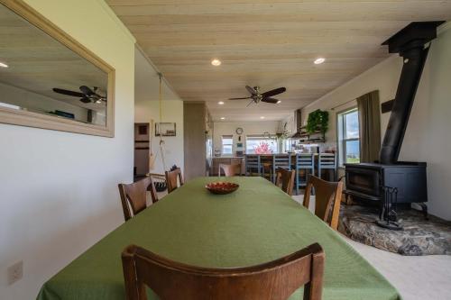 a dining room with a green table and a fireplace at Hollenback Heights - Epic Views in Eureka