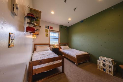 two beds in a room with green walls at Hollenback Heights - Epic Views in Eureka