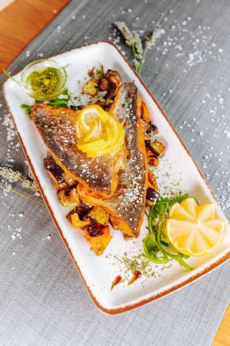 a white plate with food on a table at Hotel GOLD JET Bihać in Bihać