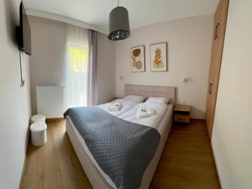 カルパチにあるApartamenty IDA - Górski Azylのベッドルーム1室(ベッド1台、白いタオル2枚付)