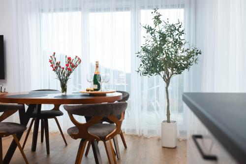 カルパチにあるApartamenty IDA - Górski Azylの木とボトルと椅子が置かれたダイニングテーブル