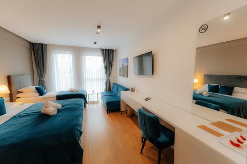 a hotel room with two beds and a desk at Hotel GOLD JET Bihać in Bihać