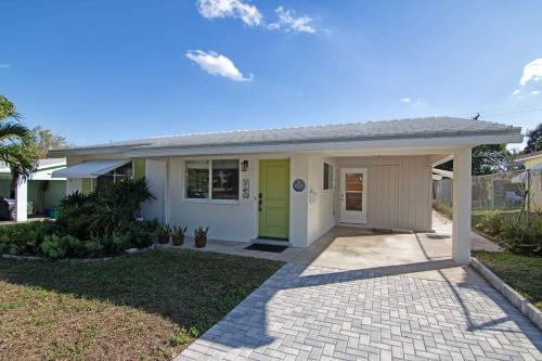 a house with a green door and a driveway at Mango House - Immaculate 3 BDR in Boynton Beach in Boynton Beach