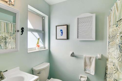 a bathroom with a toilet and a sink and a mirror at Mango House - Immaculate 3 BDR in Boynton Beach in Boynton Beach