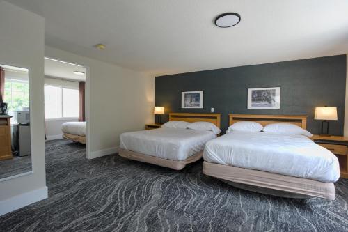 a hotel room with two beds and a wall at Park Motel in Hope