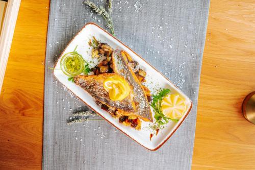 a plate of food with fish on a table at Hotel GOLD JET Bihać in Bihać