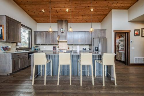 a kitchen with wooden cabinets and white chairs at Treehouse at the Wilderness Club in Eureka