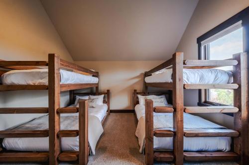 three bunk beds in a room with a window at Treehouse at the Wilderness Club in Eureka
