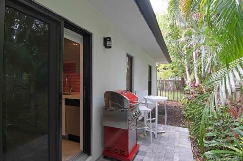 a house with a kitchen and a grill in a yard at Let your Delray Beach Getaway Begin Here in Delray Beach