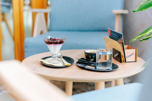 a table with a drink and two cups on it at Hotel GOLD JET Bihać in Bihać