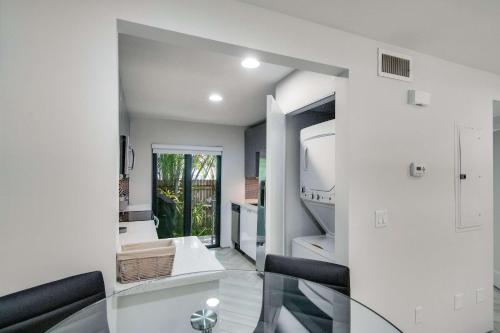 a living room with a glass table and a mirror at Delray Beach Getaway - Minutes to Beach & More in Delray Beach
