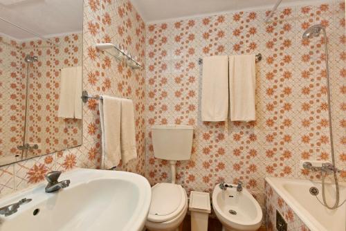a bathroom with a white sink and a toilet at Cheerfulway Minichoro Apartamentos in Albufeira