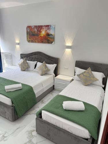 a bedroom with two beds with green and white sheets at REHAN VENICE STATiON in Venice