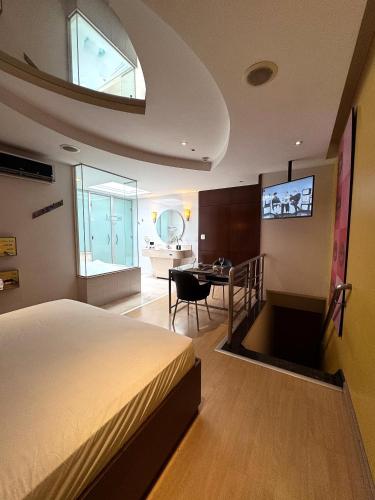 une chambre avec un lit, une table et une télévision dans l'établissement Lumini Motel, à São Paulo