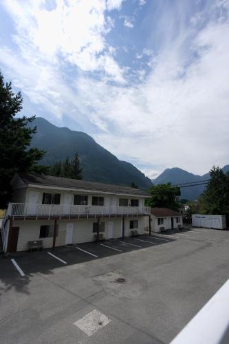 a building with a parking lot with mountains in the background at Park Motel in Hope