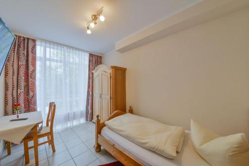 a bedroom with a bed and a table and a window at Hotel Gasthof Hainzinger in Einsbach