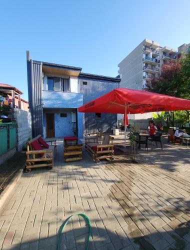 a patio with tables and chairs and a red umbrella at Arkadia in K'obulet'i