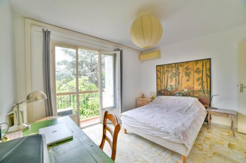 une chambre avec un lit, un bureau et une fenêtre dans l'établissement Charmant 47 m au calme, à Nice