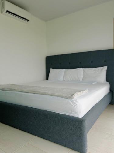 a large bed with white sheets and pillows at Hotel Vista Al Mar in Capurganá