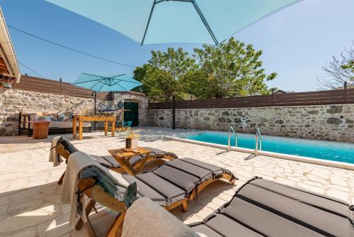 a patio with lounge chairs and a swimming pool at Filotea in Smrdelje