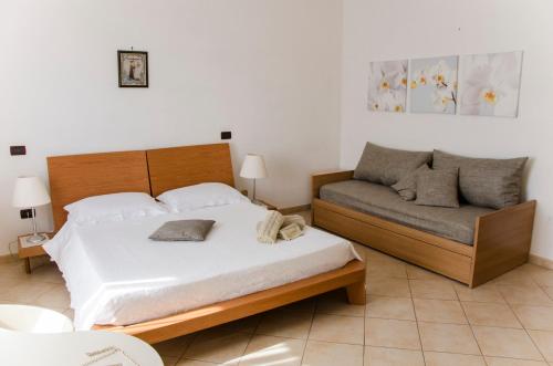 a bedroom with a bed and a couch at B&B Ore Liete in Martano