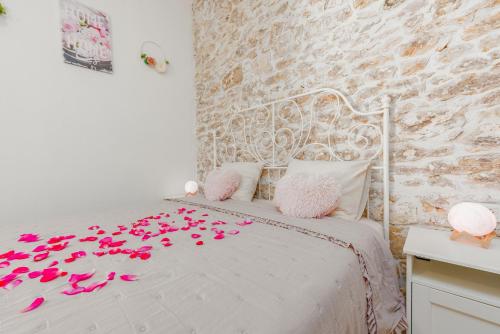 a bedroom with a bed with pink petals on it at Filotea in Smrdelje