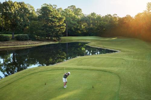 a man is playing golf on a golf course at Margaritaville Lake Resort, Lake Conroe in Montgomery