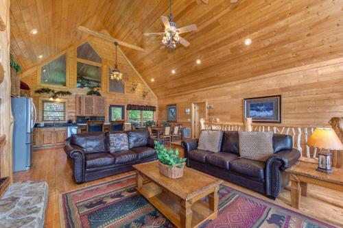 un soggiorno con divani in pelle e una cucina di Cabin with Hot Tub Theater & Views - Sleeps 22 a Sevierville