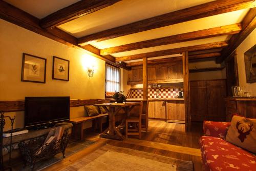 a living room with a table and a television at Au Coeur Des Neiges Resort SPA & FREE E-BIKE in Courmayeur