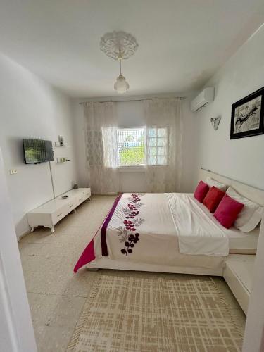 a bedroom with a large bed and a window at Villa Mer in Nabeul