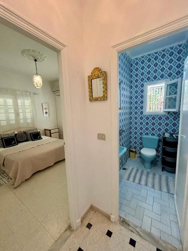 a bedroom with a bed and a bathroom with a toilet at Villa Mer in Nabeul