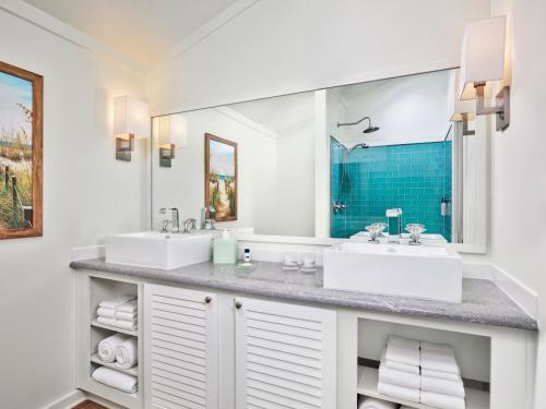 a bathroom with two sinks and a large mirror at Margaritaville Lake Resort, Lake Conroe in Montgomery
