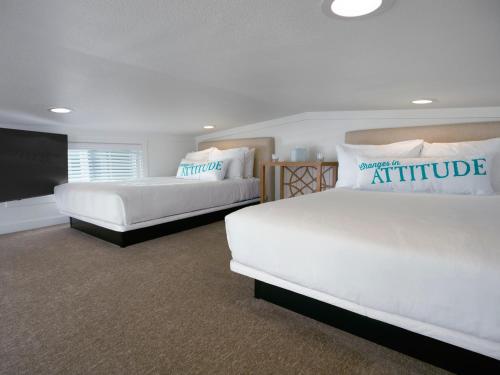 a bedroom with two beds and a flat screen tv at Margaritaville Lake Resort, Lake Conroe in Montgomery