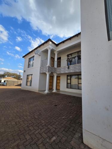 a white house with a brick driveway at Lido System Makonde Village in Thohoyandou