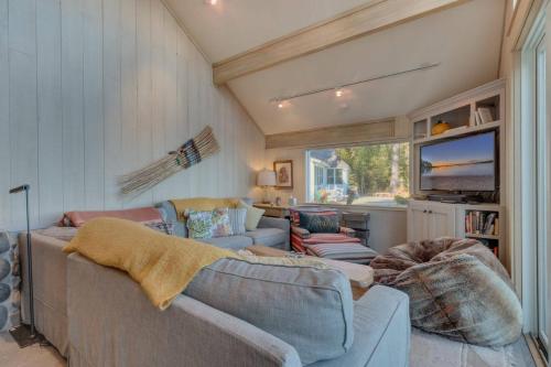a living room with two couches and a tv at Belleview Lakefront by Tahoe Getaways - Hot Tub, Pier, Buoy and Guest House in Homewood