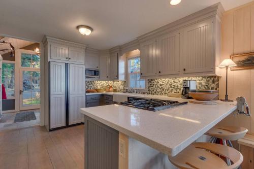 a kitchen with white cabinets and a counter top at Belleview Lakefront by Tahoe Getaways - Hot Tub, Pier, Buoy and Guest House in Homewood