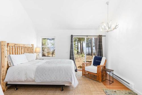 a bedroom with a bed and a chair and a window at Belleview Lakefront by Tahoe Getaways - Hot Tub, Pier, Buoy and Guest House in Homewood