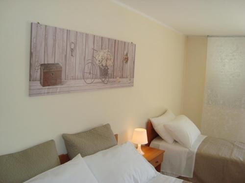 a bedroom with two beds and a picture of a bicycle on the wall at Zagarella House in Catania