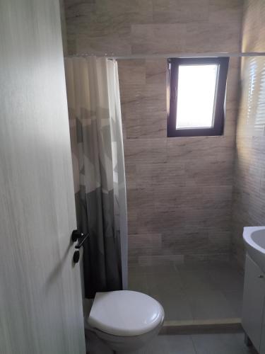 a bathroom with a toilet and a window at Beautiful view apartment Tivat in Tivat