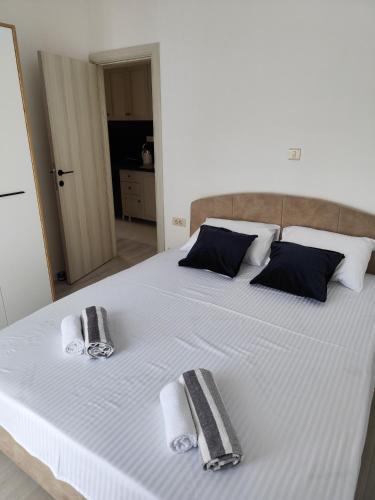 a large white bed with two towels on it at Beautiful view apartment Tivat in Tivat