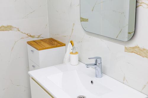 a bathroom with a white sink and a mirror at Red apple in Kastoria