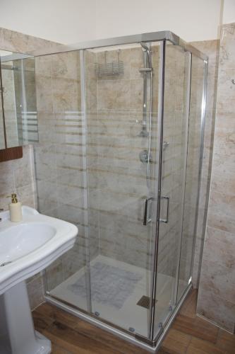 a shower with a glass door next to a sink at La Meridiana in Caprarola