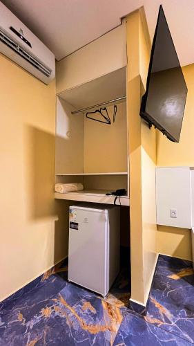 a small kitchen with a refrigerator in a room at Hotel Amazonida in Manaus