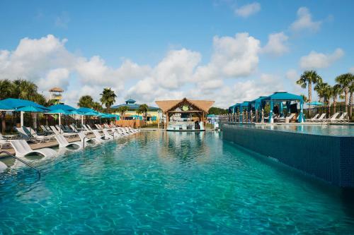 a swimming pool at a resort with chairs and umbrellas at Margaritaville Lake Resort, Lake Conroe in Montgomery