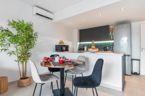 a kitchen with a table and chairs in a room at Charmant duplex moderne proche plage Anse Marcel in Anse Marcel 