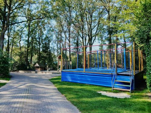 a batting cage in a park with a playground at Familiechalet Vechtdal in Diffelen
