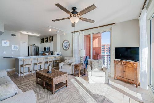 a living room with a couch and a tv and a table at Sunset Shores - Oceanfront Condo Bliss in Panama City Beach