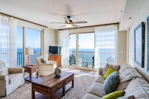 a living room with a couch and a table at Sunset Shores - Oceanfront Condo Bliss in Panama City Beach