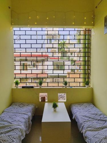 two beds in a room with a brick wall at Nomad's Nest Backpackers Hostel in Guwahati