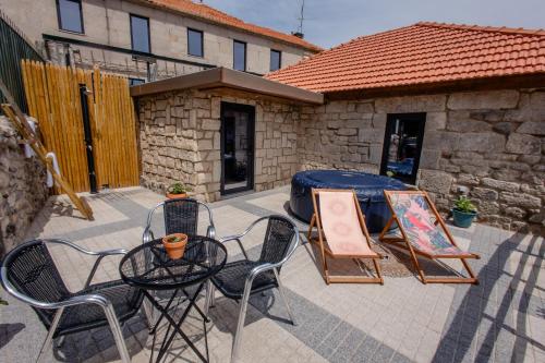 a patio with a table and chairs and a tent at Open Space com Jacuzzi a 5 mn do centro de Lamego in Lamego